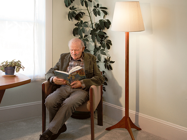 Man sitting next to a sturdy livingroom lamp