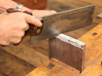 Hand sawing a dovetail pin