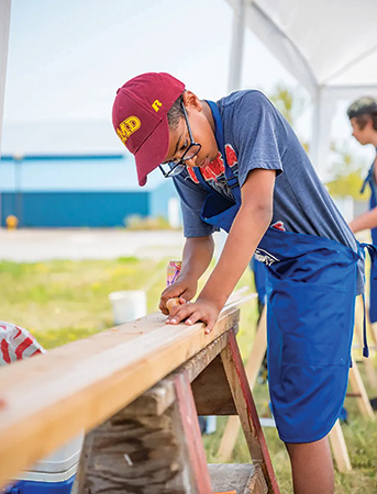 Kid planing a board